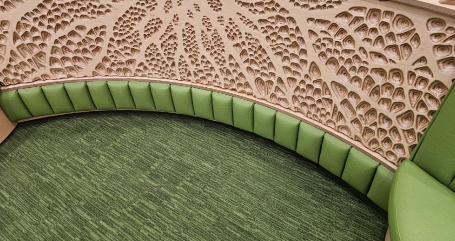 Carved root lattice behind curved green seating